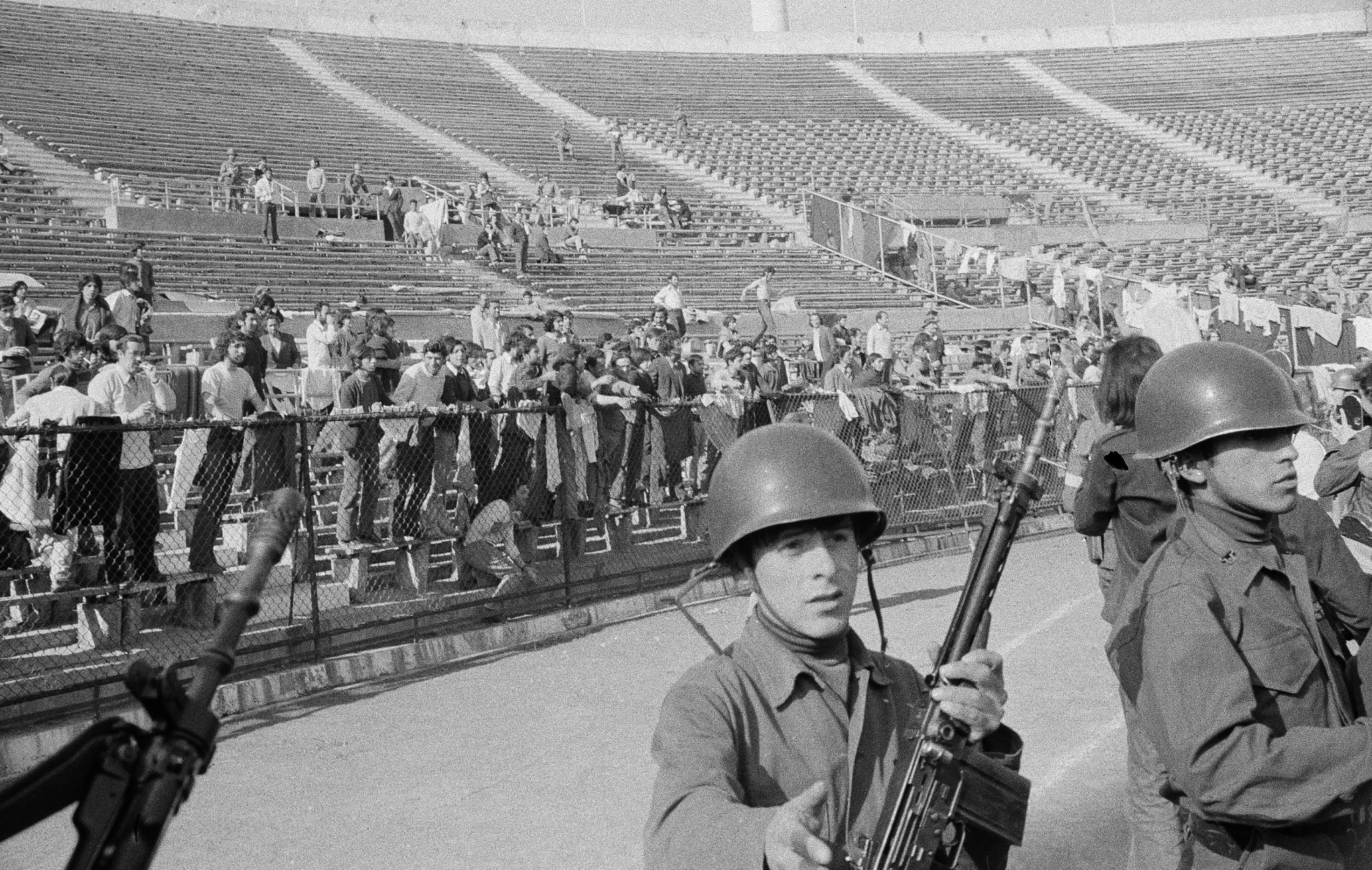 Chilean soldiers guarding detainees inside Estadio Nacional in 1973, with people held in the stands during the first weeks after the coup.