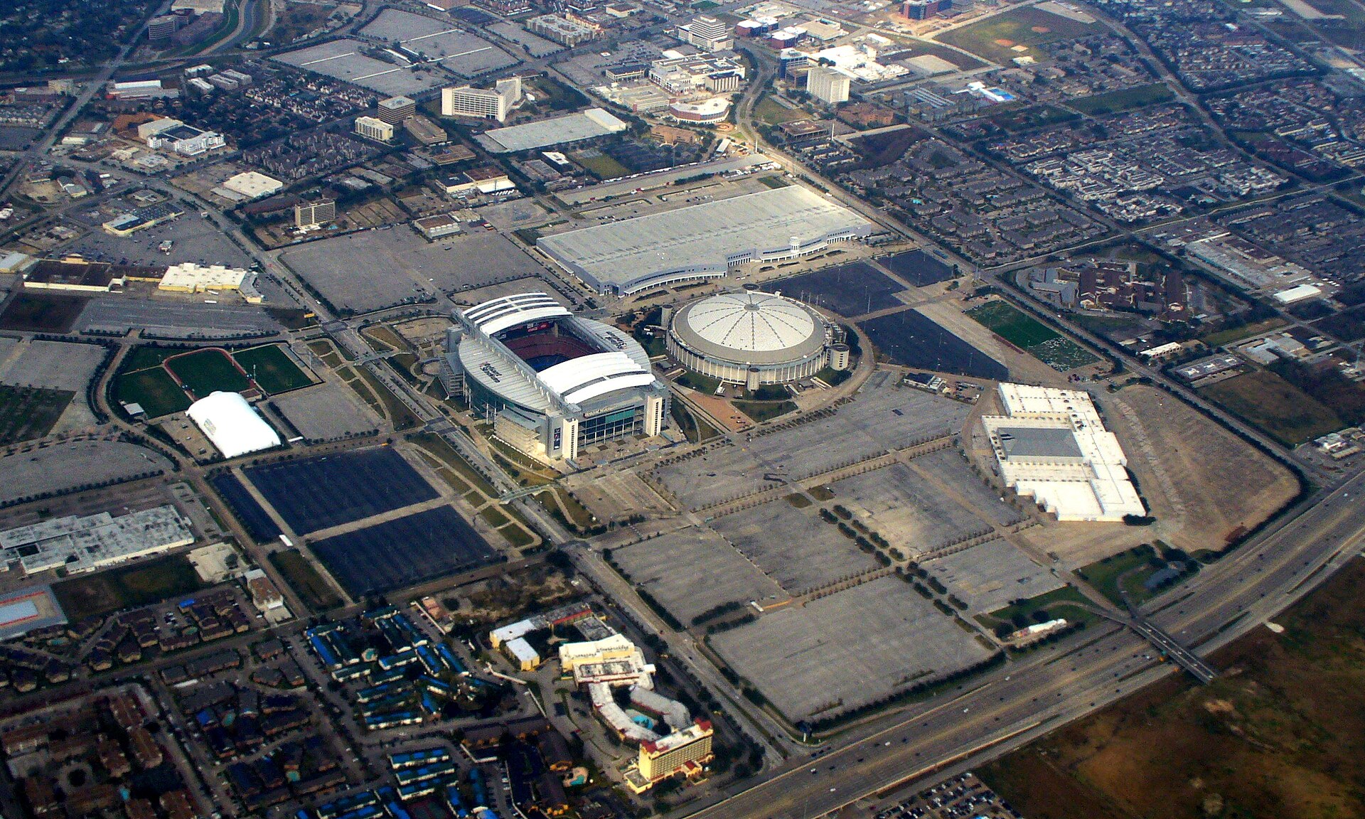 Aerial view of NRG Stadium and the Astrodome in Houston, showing both stadiums side by side within the wider event complex.